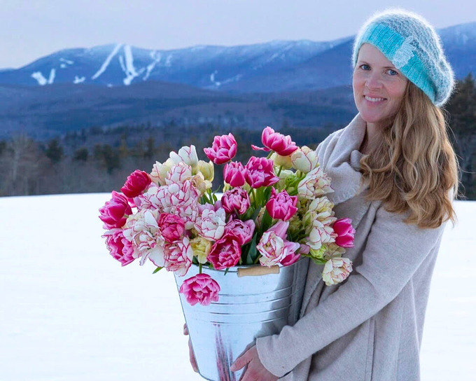 emily von trapp and a bucket of beautiful tulips in front of snowy mad river glen